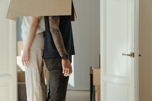 Free Woman in Blue Denim Jeans Holding Brown Cardboard Box Stock Photo